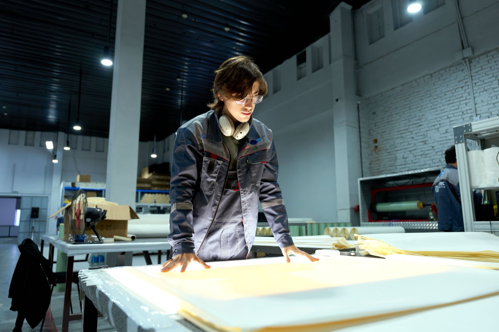 A manufacturing worker inspecting material on the shop floor